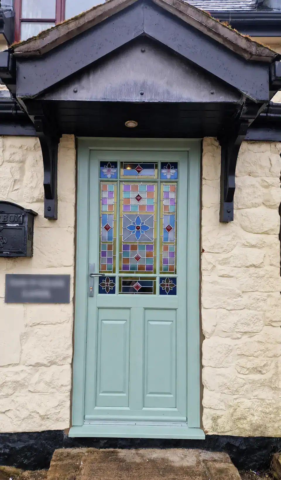 Glass and Glazing in Ely featuring a Chartwell green entrance door with colourful decorative leaded glass panels.