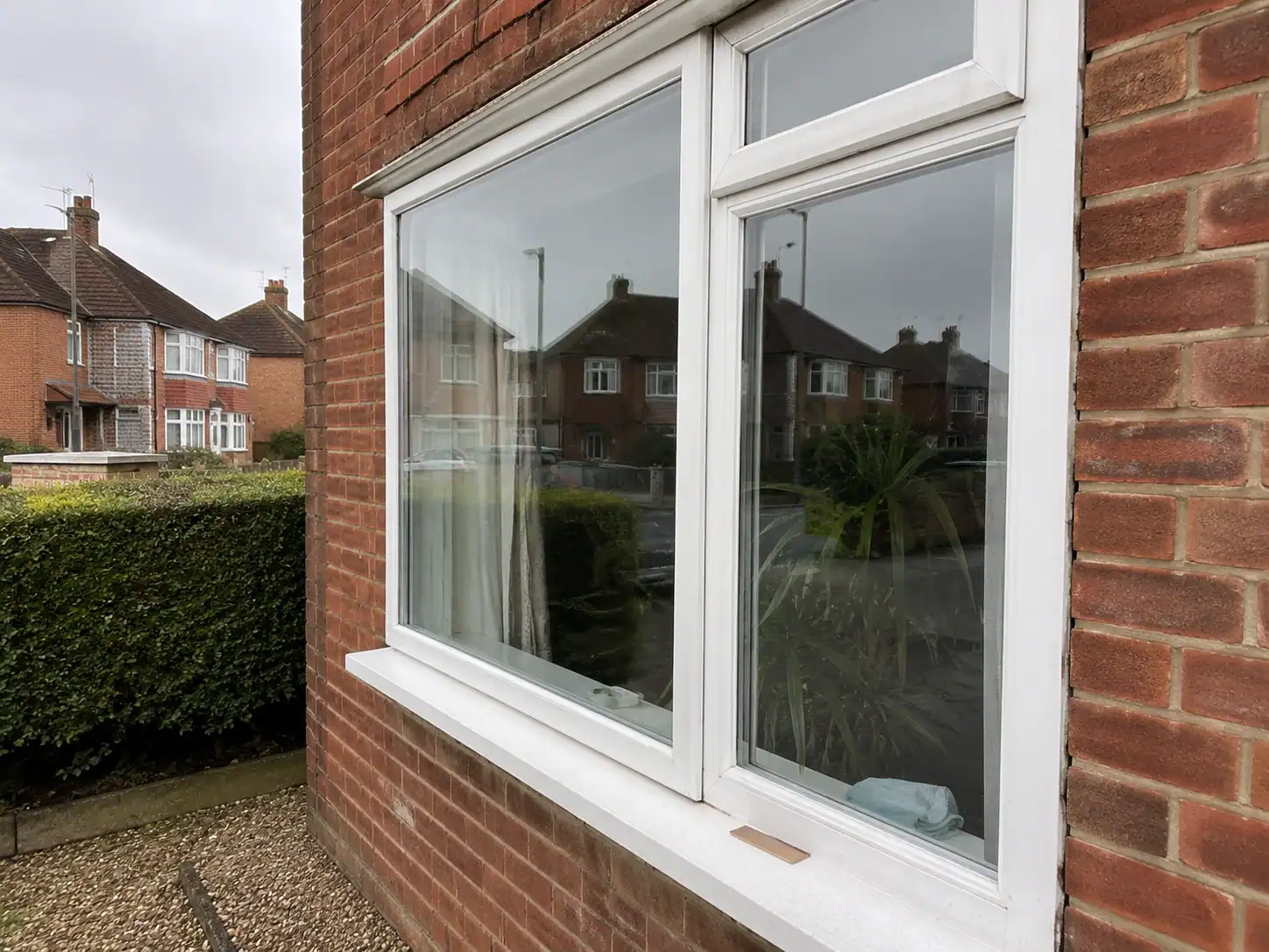 Exterior view of white-framed windows with secondary glazing fitted at a red-brick home in Ely.