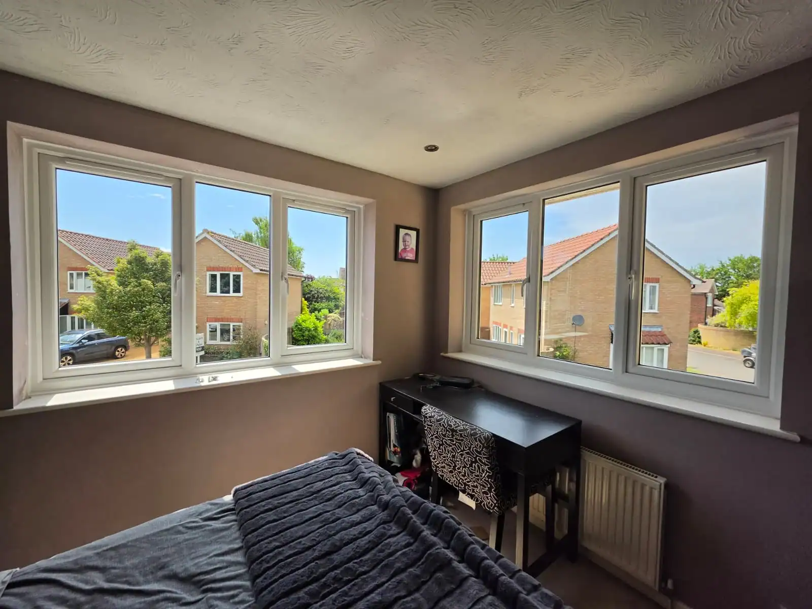 White uPVC windows in Ely viewed from inside a bedroom, with multiple casement sections bringing in natural light.