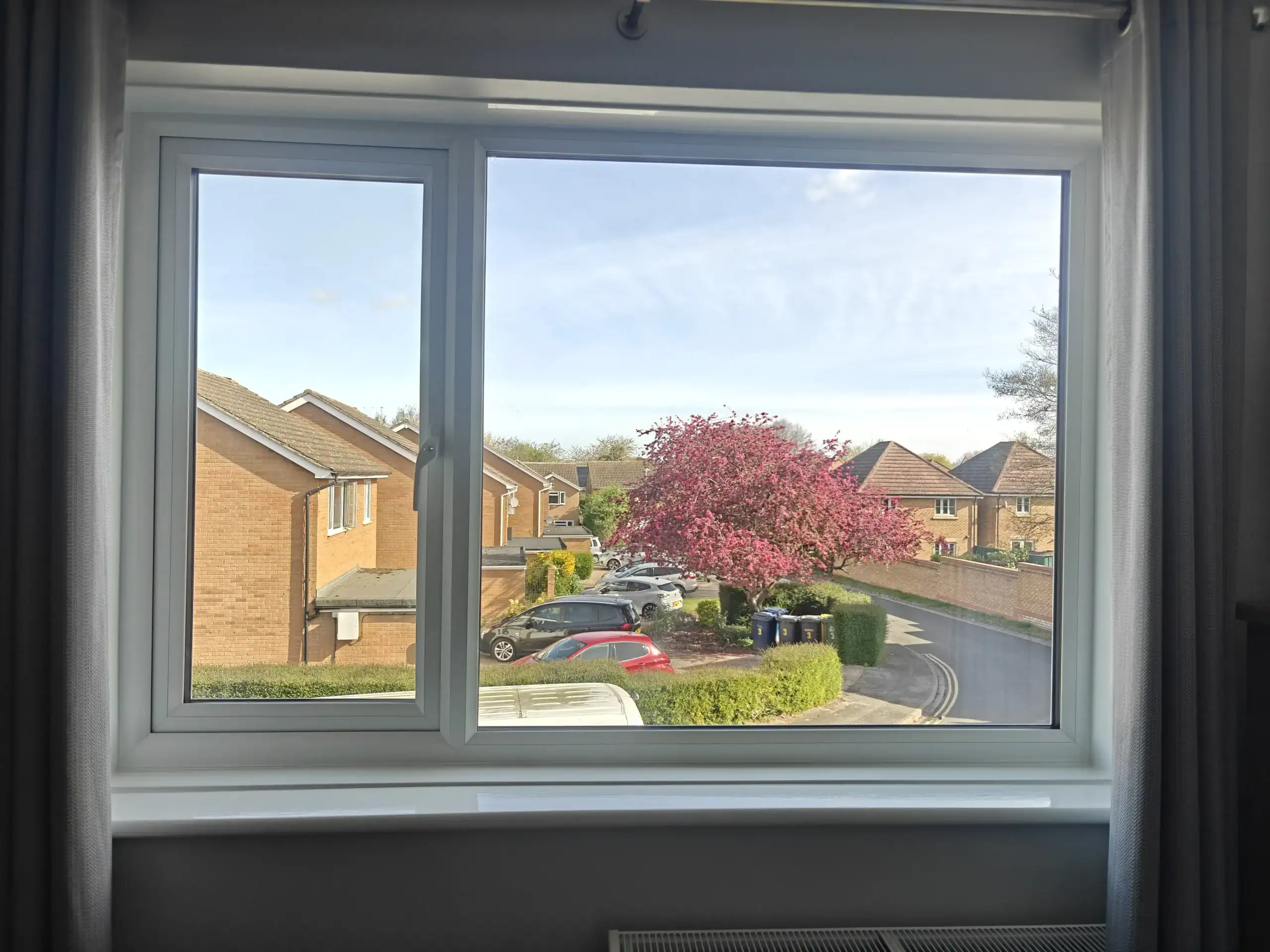 White uPVC windows in Ely overlooking a residential street from inside a home.