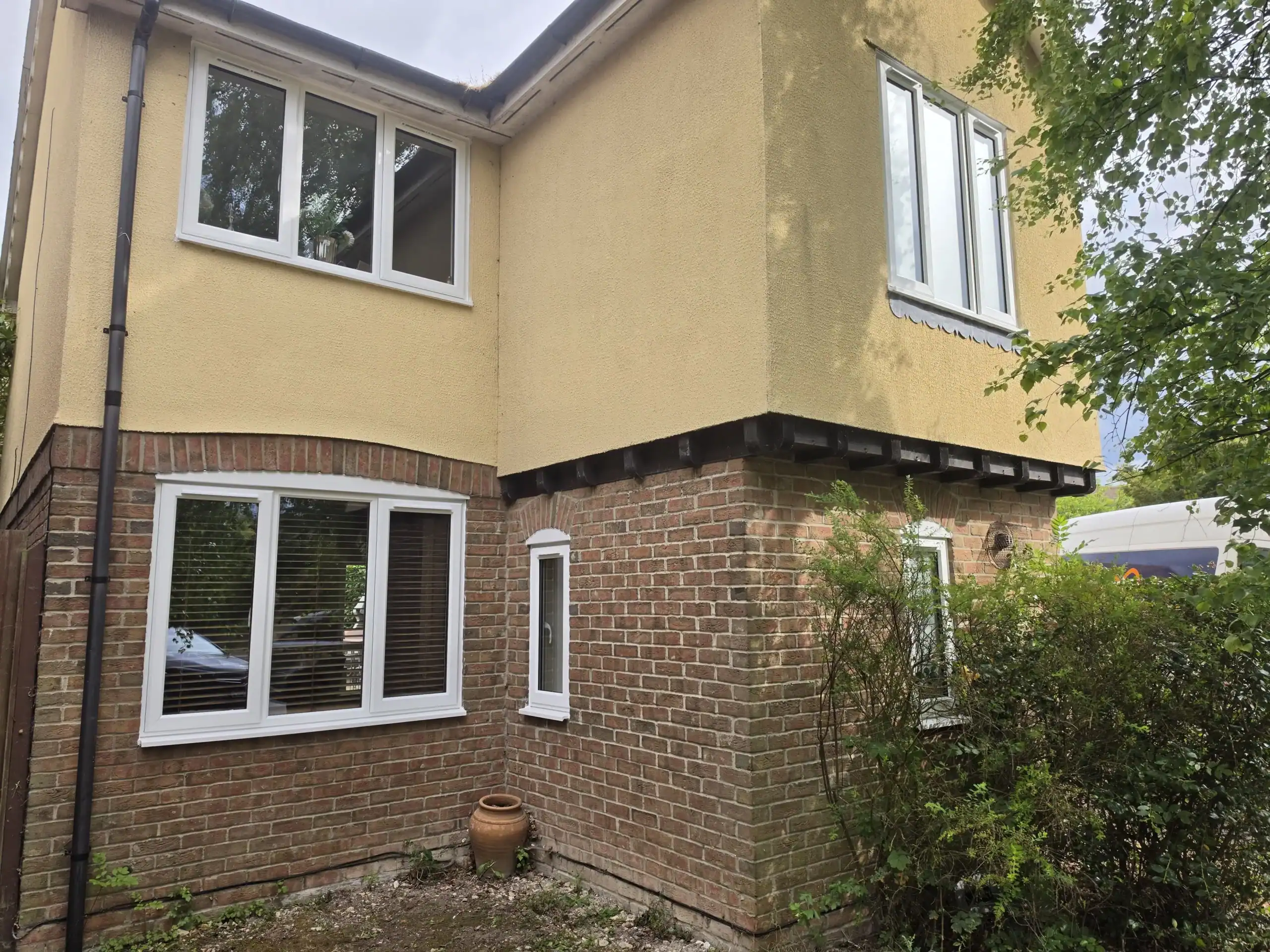 White uPVC windows in Ely fitted to the ground and first floors of a brick and rendered home.