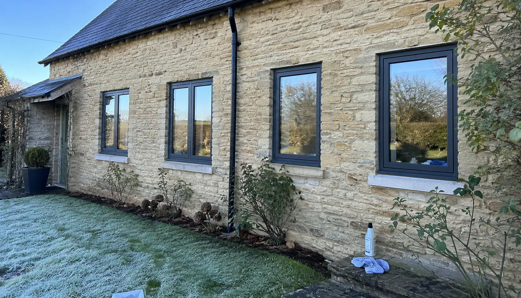 Anthracite aluminium windows on a stone cottage, showcasing a design option for Double Glazing in Ely.