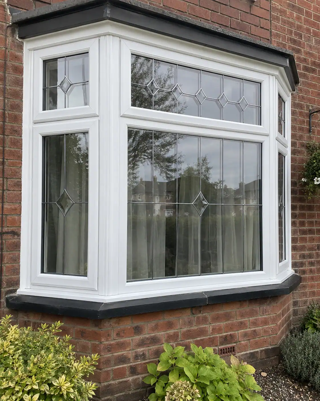 Double Glazing in Ely – white uPVC bay window featuring diamond-pattern leaded glass and a contrasting dark sill.