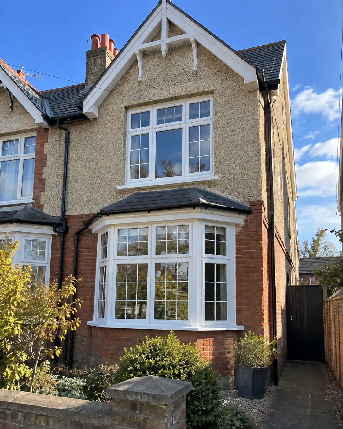 Double Glazing in Ely – white uPVC bay and first-floor windows with decorative glazing bars on a period-style house.